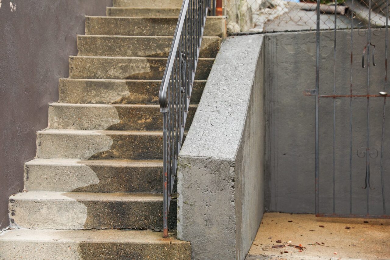 Ouvriers installant un escalier en béton sur un chantier résidentiel.
